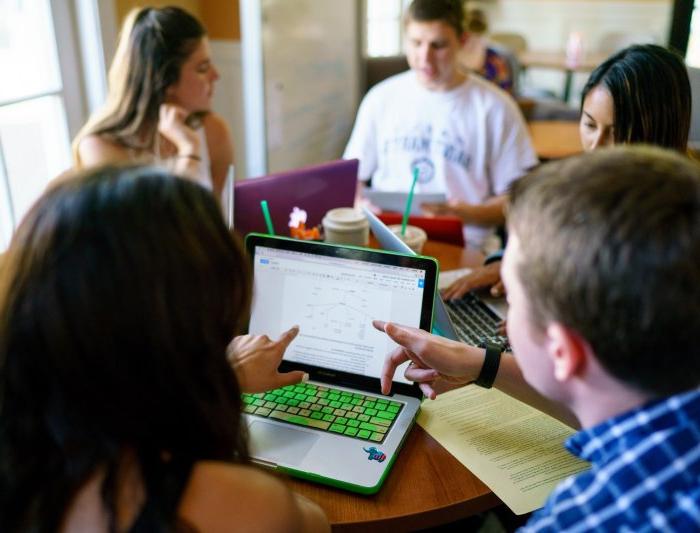 A Writing Circle Facilitator and a writer looking at a laptop screen.